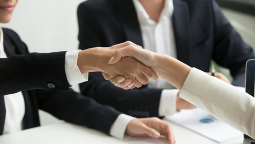 two-people-shaking-hands-in-front-of-a-laptop.jpg two people shaking hands in front of a laptop